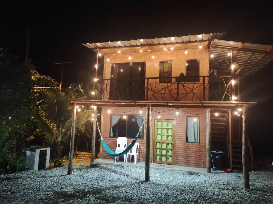 una casa con un'amaca di fronte ad essa di notte di Cayo Ecovillage a Puerto Cayo