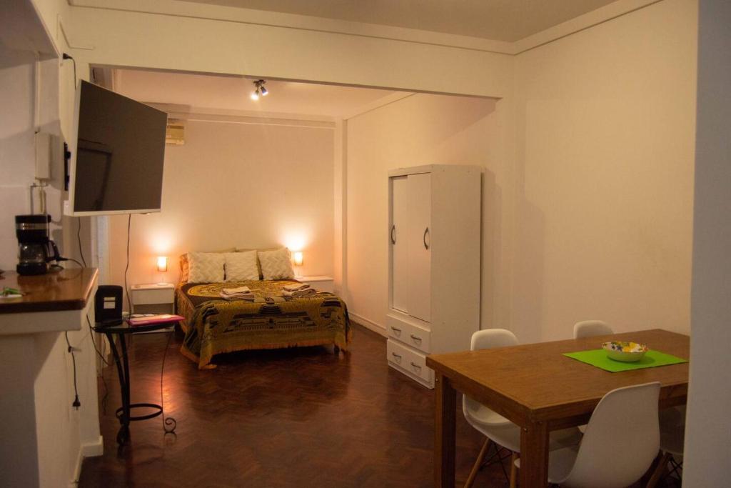 Habitación con cama, mesa y comedor. en Acogedor Monoambiente en Palermo en Buenos Aires