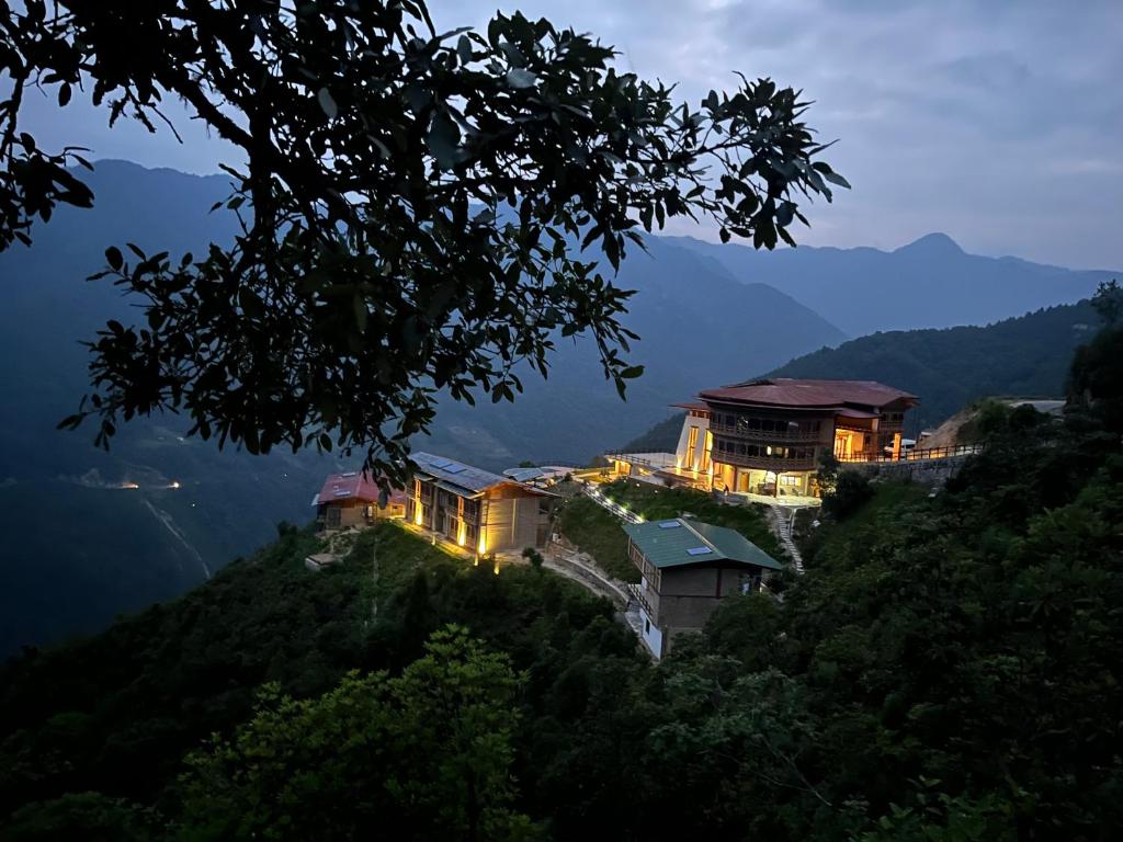 a building on top of a hill at night at Willing Resort, Trongsa in Kagha