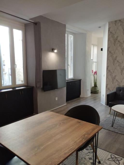 un salon avec une table en bois et une télévision à écran plat dans l'établissement Appartement avec terrasse, à Malaucène