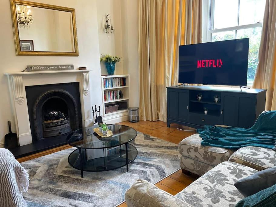a living room with a television and a fireplace at The Regal at Penarth by MGroupSA in Cardiff