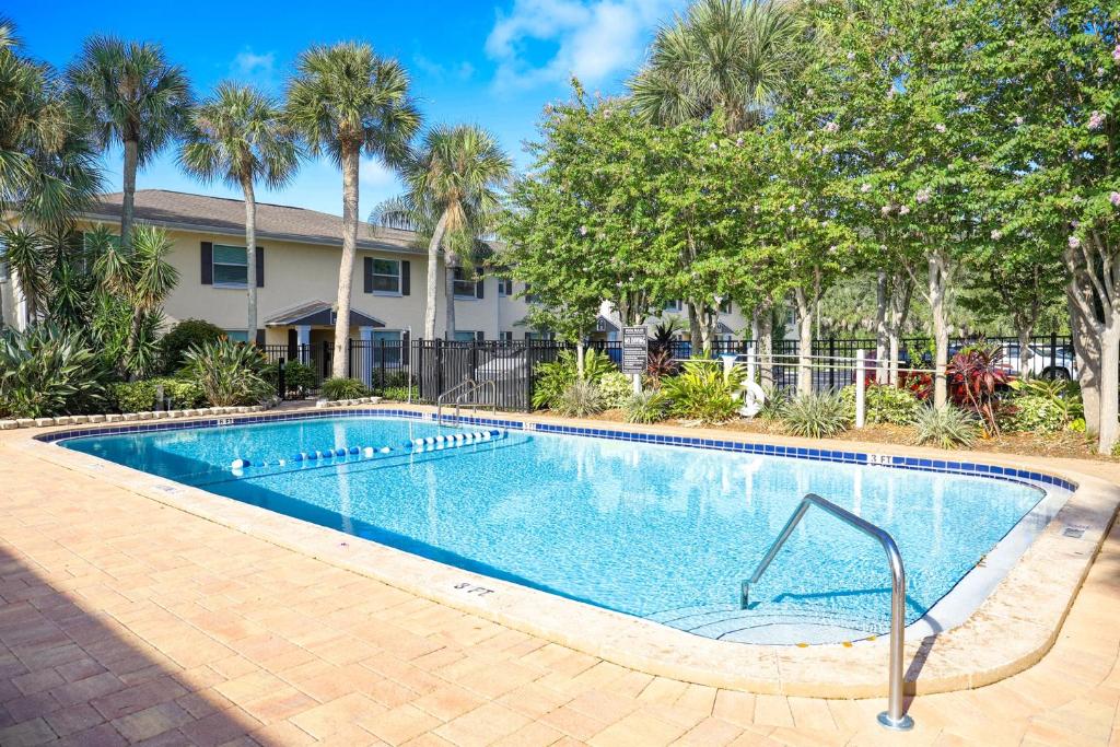 拉哥的住宿－Sunnyside Palms - 2BR, Poolside, 5 min to Beach，棕榈树屋前的游泳池