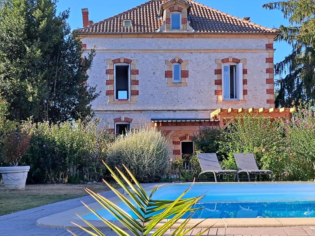 a house with a swimming pool in front of a house at au milieu coule la Garonne 