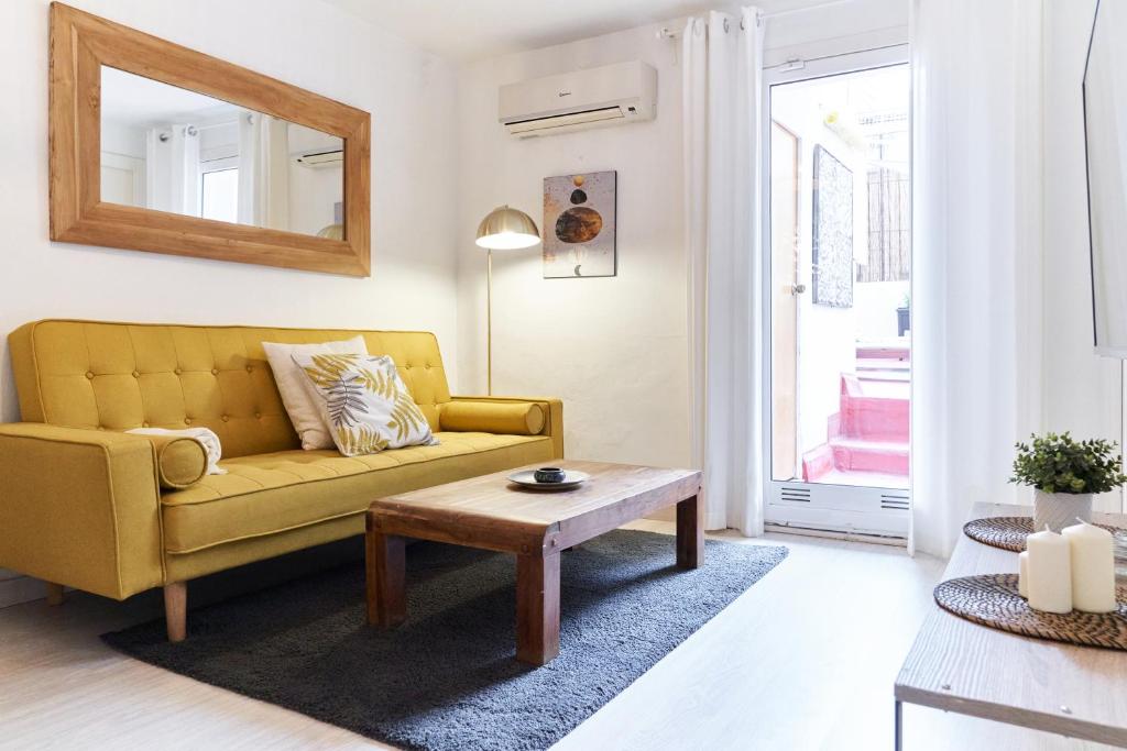 salon z żółtą kanapą i stołem w obiekcie HA Diputació terrace apartment w Barcelonie