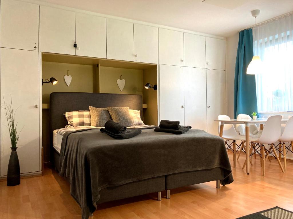 a bedroom with a bed with white cabinets and a table at Ferienwohnung RelAction in Winterberg