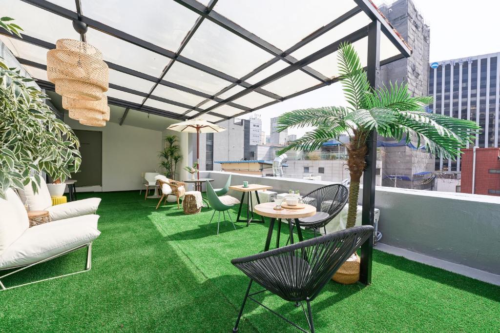 a rooftop patio with a table and chairs and plants at Hotel Chloe in Seoul