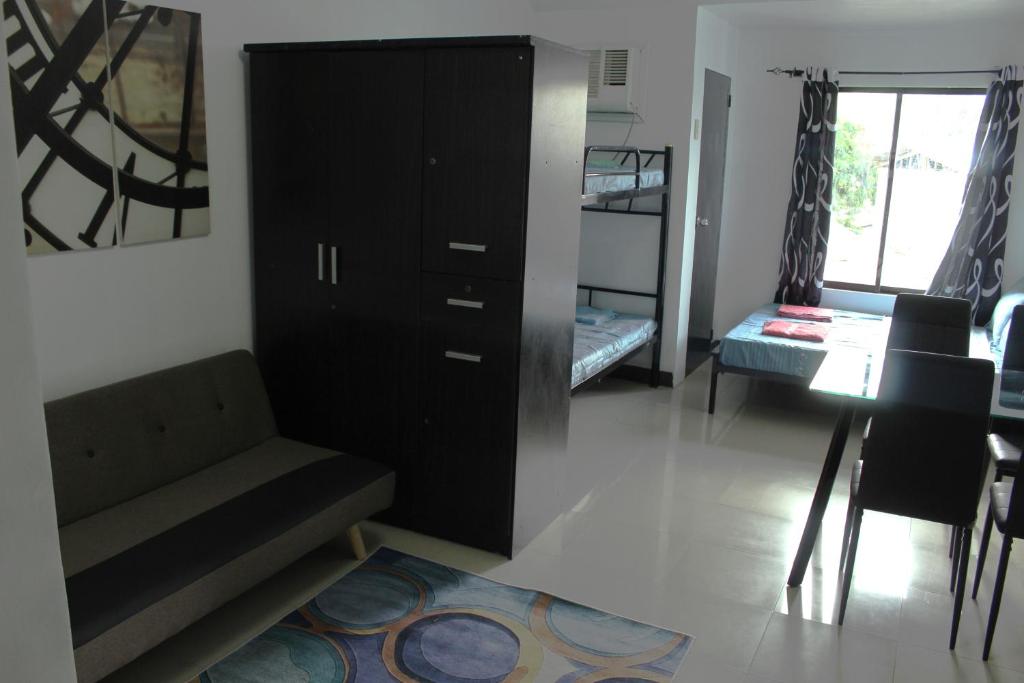 a living room with a black cabinet and a table at Large New Studio Up to 6 Pax in Cebu City