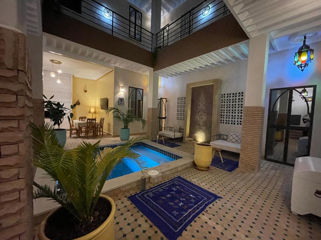 una sala de estar con piscina y una casa en Riad Samarine, en Marrakech