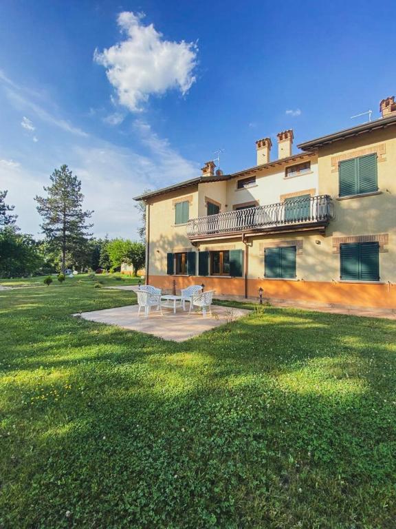 a large house with a table and chairs in a yard at Agriturismo Villa Tadina in Gualdo Tadino