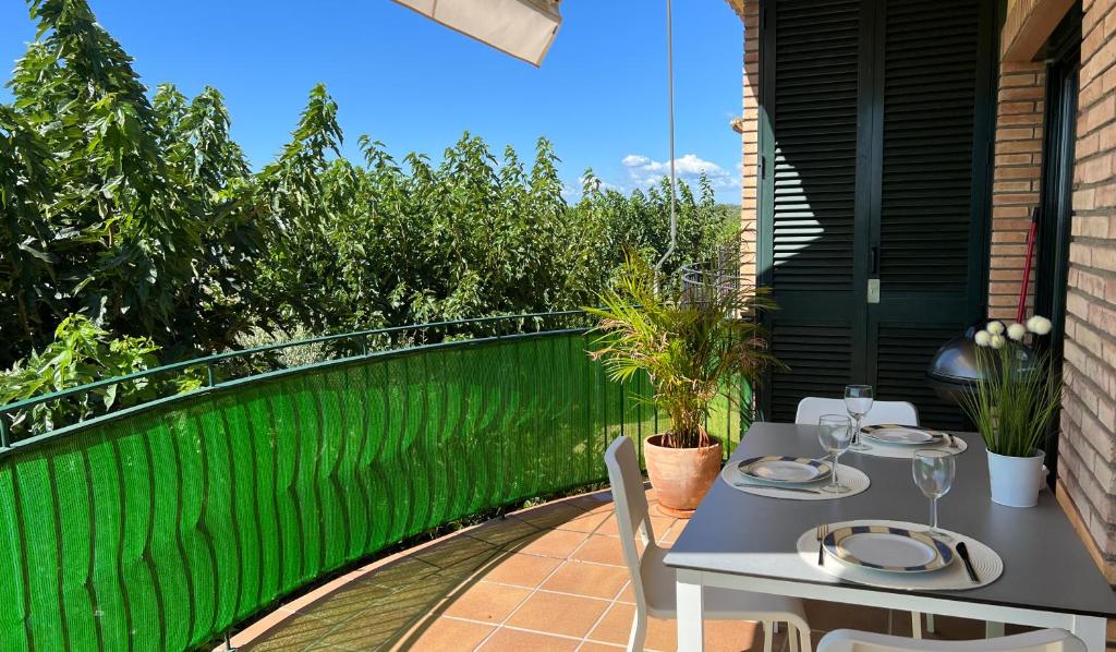 a table and chairs on a balcony with a green fence at Pinea in Vilacolum