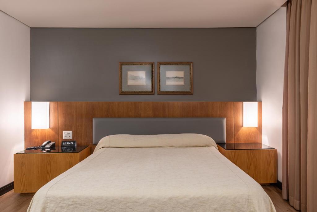 um quarto com uma cama grande e 2 mesas de cabeceira em DELPLAZA Timbiras São Paulo em São Paulo