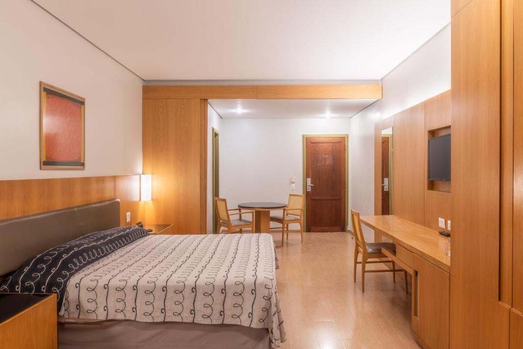 サンパウロにあるDELPLAZA Excelsior São Paulo - By Monrealeのベッドルーム1室(ベッド1台、テーブル、椅子付)