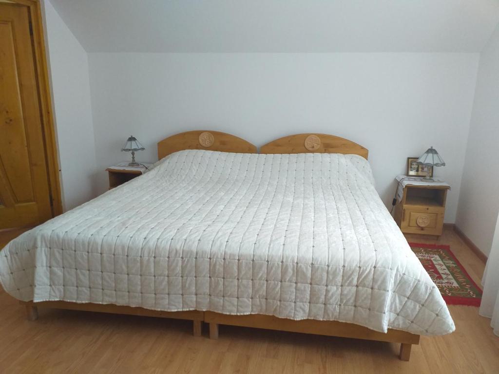 Pensiunea Gură de Rai, Pojorâta في بوغوريتا: غرفة نوم مع سرير مع لحاف أبيض