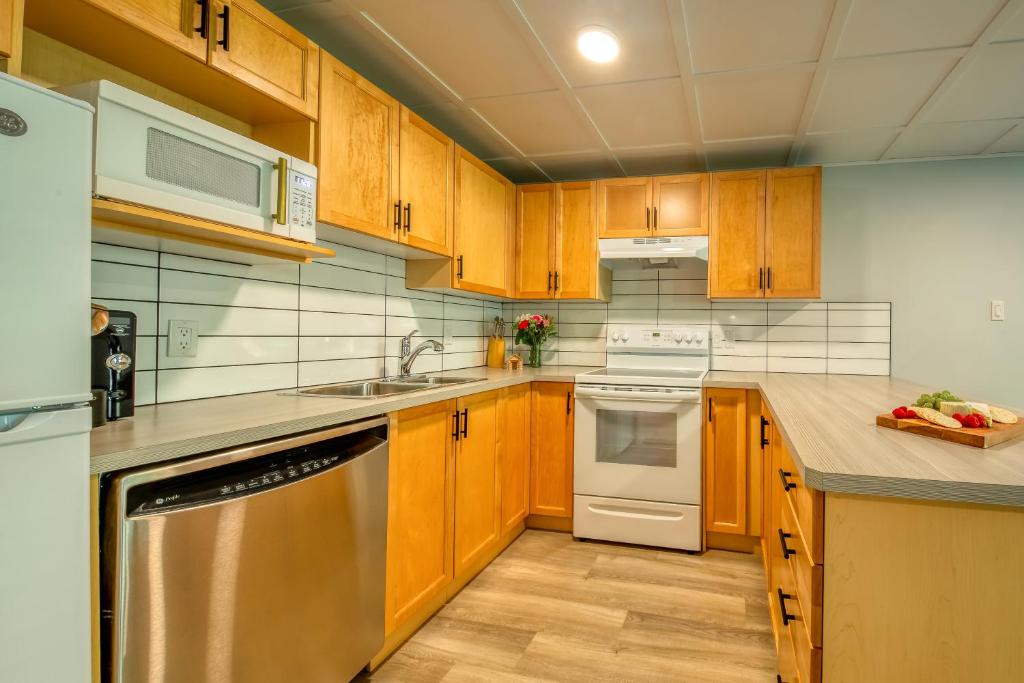 eine Küche mit Holzschränken und weißen Geräten in der Unterkunft Panorama Resort 2 Bedroom Creekside Condo in Panorama
