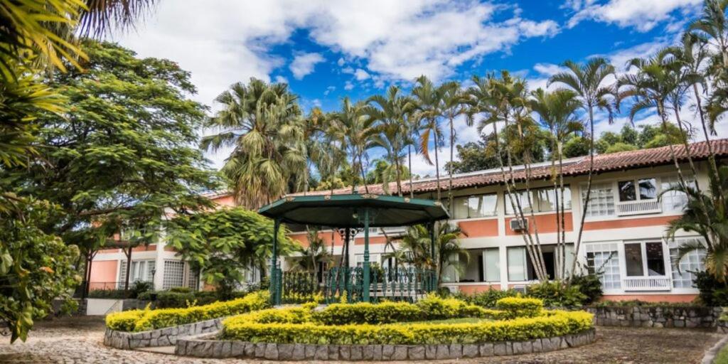 a building with a garden in front of it at HOTEL FAZENDA ROCHEDO in Conservatória