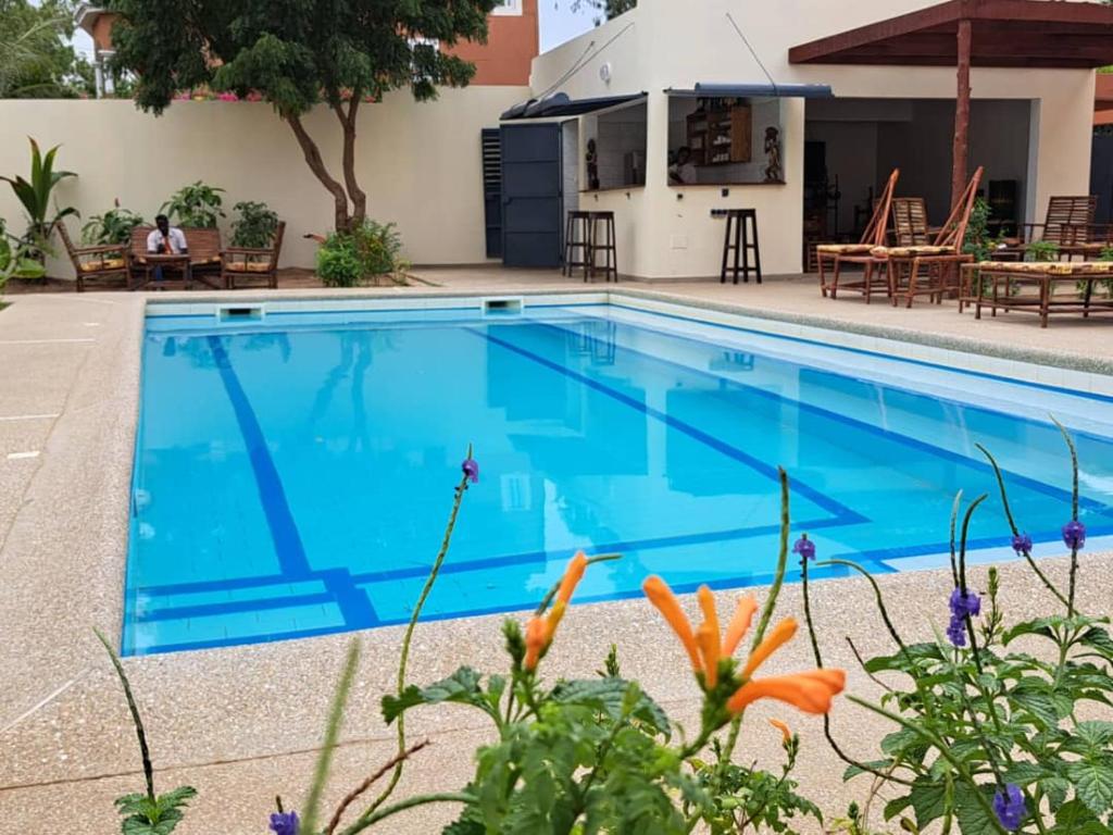 una piscina de agua azul frente a un edificio en Le Kenkeni, en Ouoran