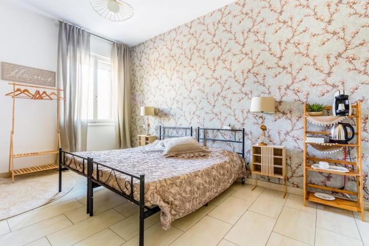 1 dormitorio con 1 cama y papel pintado con motivos florales en La finestra sulla fiera en Bolonia
