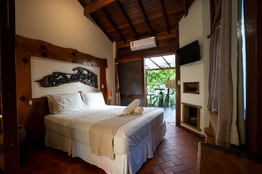a bedroom with a bed in a room with a fireplace at Pousada Astral da Ilha in Ilha do Mel