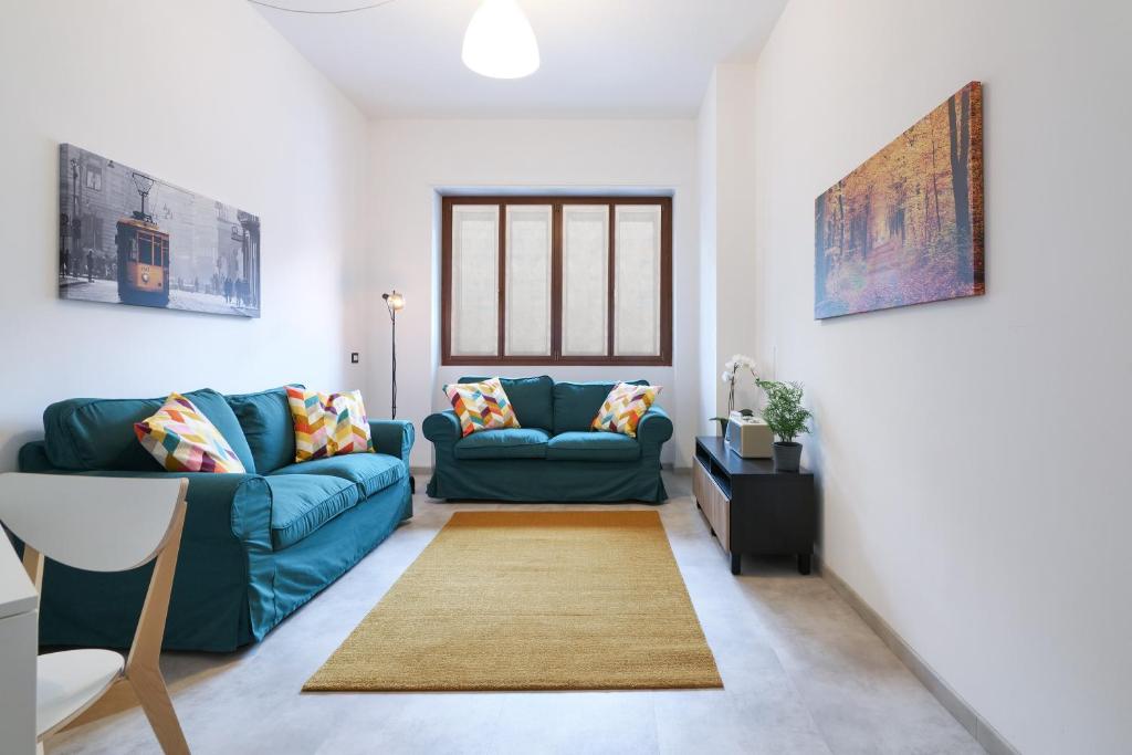 una sala de estar con 2 sofás azules y una alfombra en PrimoPiano - K51, en Milán