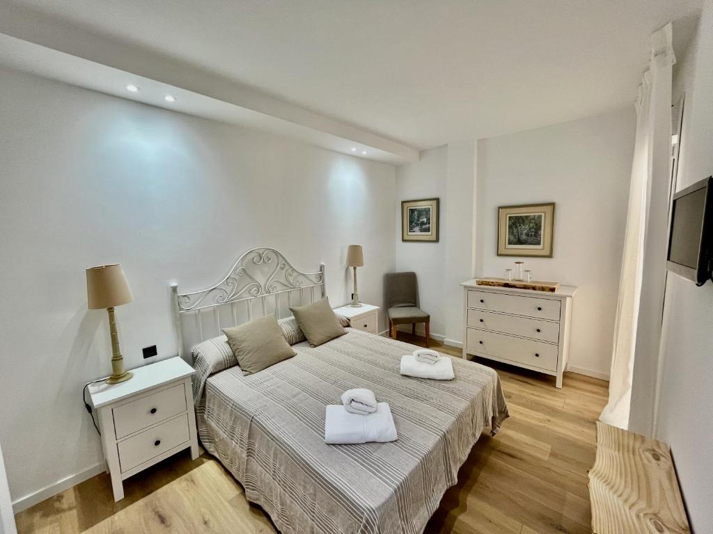 a bedroom with a bed with two towels on it at NEW CAPUCHINOS Apartment 1 in Málaga