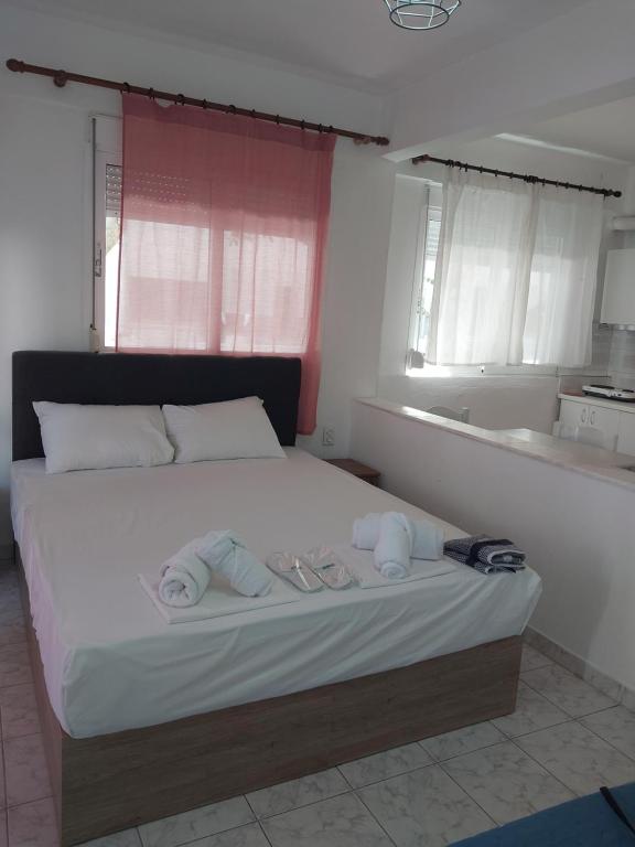 a bedroom with a large bed with towels on it at PELEKAN rooms and apartments athina 11 in Pefkochori