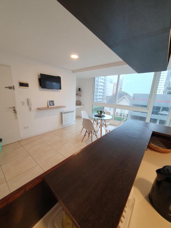ein großes Wohnzimmer mit einem Tisch und einem TV in der Unterkunft La Perla Moderno 2 Amb a 100 mts del Mar in Mar del Plata