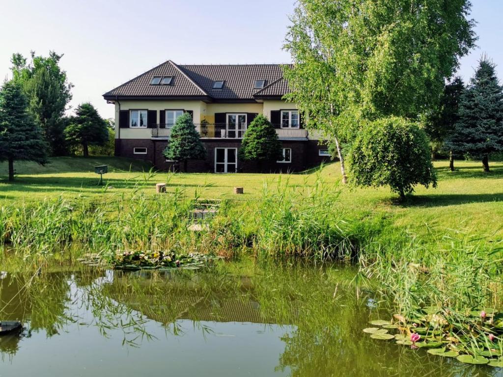 una casa con un estanque delante de ella en Siedlisko nad stawem, en Ełk