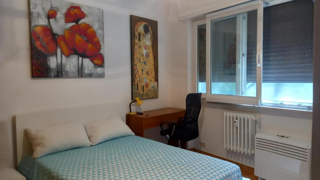 a bedroom with a bed and a desk and a window at Camera Parioli con uso cucina in Rome
