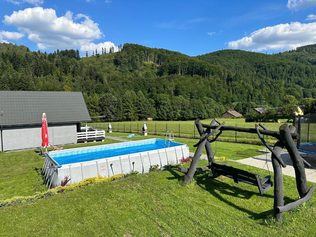 a swimming pool in the middle of a grass field at Siedlisko Leśnica - domki całoroczne Brenna in Brenna