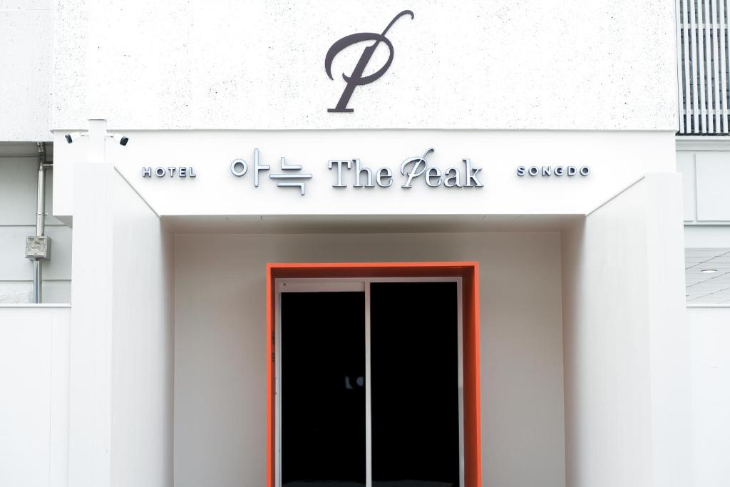 Aank Thepeak Hotel Incheon Songdo في انشيون: لوحة على واجهة مبنى مع باب