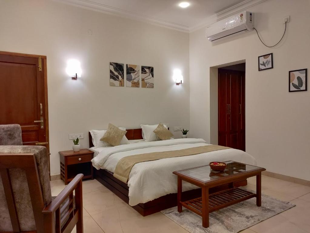 a bedroom with a large bed and a table at The Cana's Coorg in Ammatti