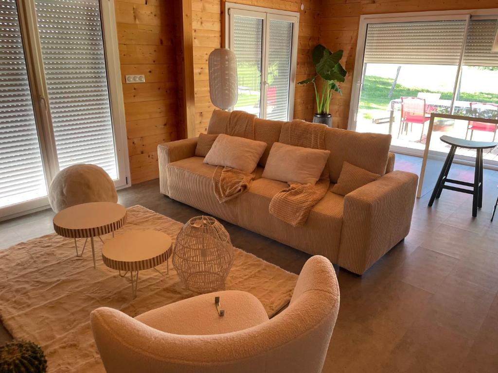 een woonkamer met een bank, stoelen en tafels bij CHEZ NOUNOU in Souvans