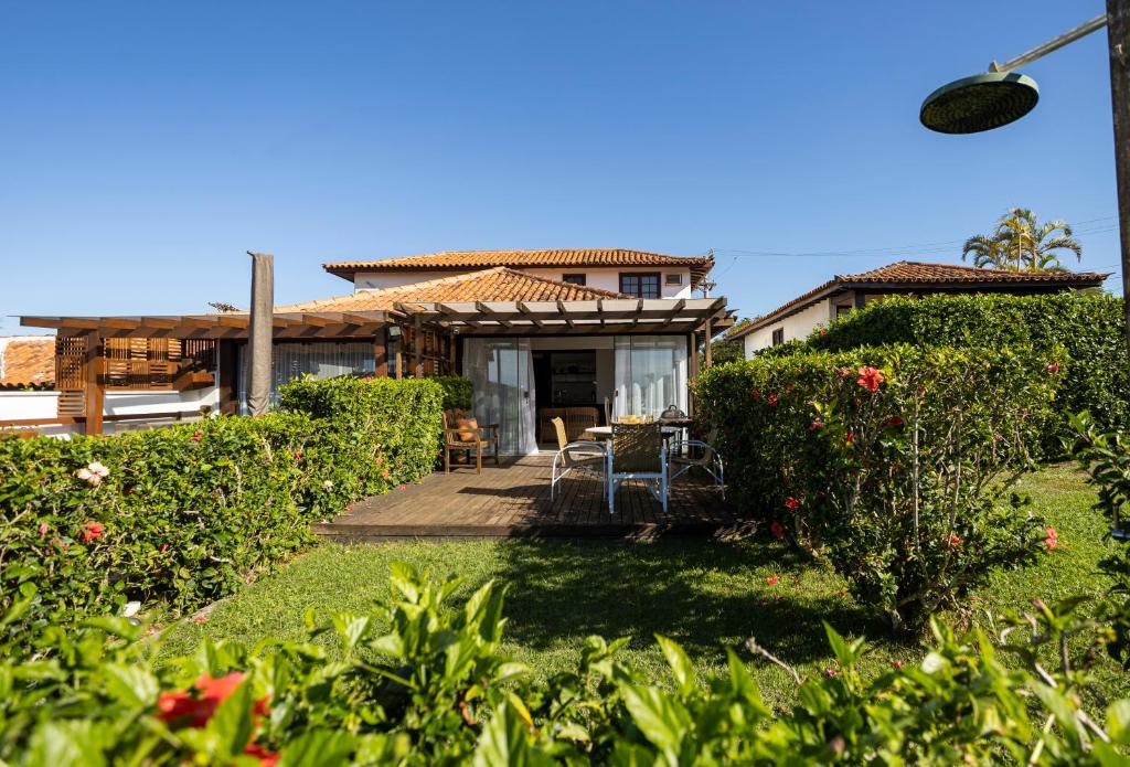 a house with a patio and a yard with plants at Casa com Vista Mar e 2 Suítes | CBR 07 in Búzios