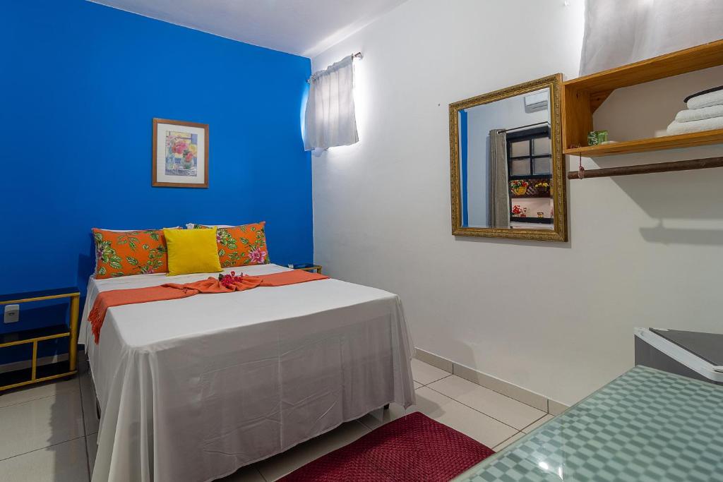 um pequeno quarto com uma cama com uma parede azul em Magia D'ajuda Hospedagem em Arraial d'Ajuda