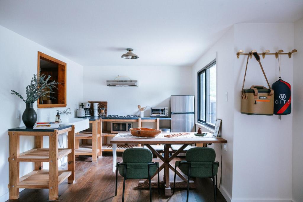 uma cozinha com uma mesa e algumas cadeiras verdes em The Leeway em Mount Tremper