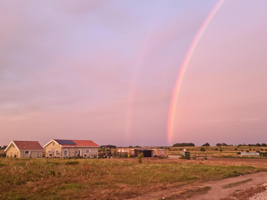 a rainbow in the sky over a house at 3 ruoniai in Palanga