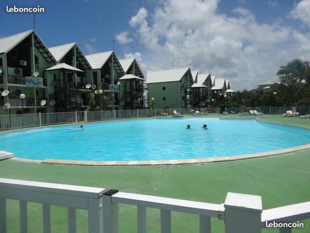 - une grande piscine avec des personnes à l'eau dans l'établissement STUDIO VUE MER VILLAGE VIVA BAS DU FORT, Gosier, au Gosier