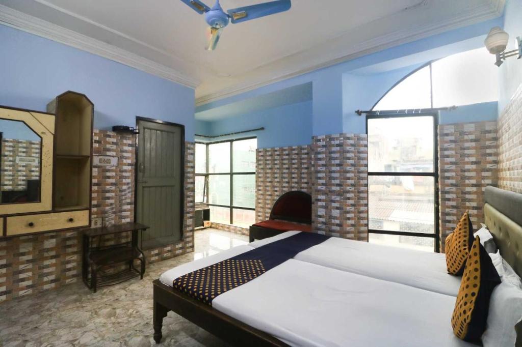 - une chambre avec un lit, une chaise et des fenêtres dans l'établissement Flagship Hotel Maitry, à Cuttack