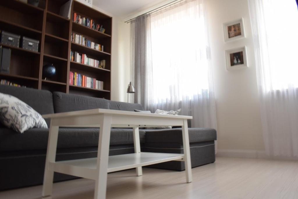 a living room with a couch and a table at Blue Sky Apartment in Poznań
