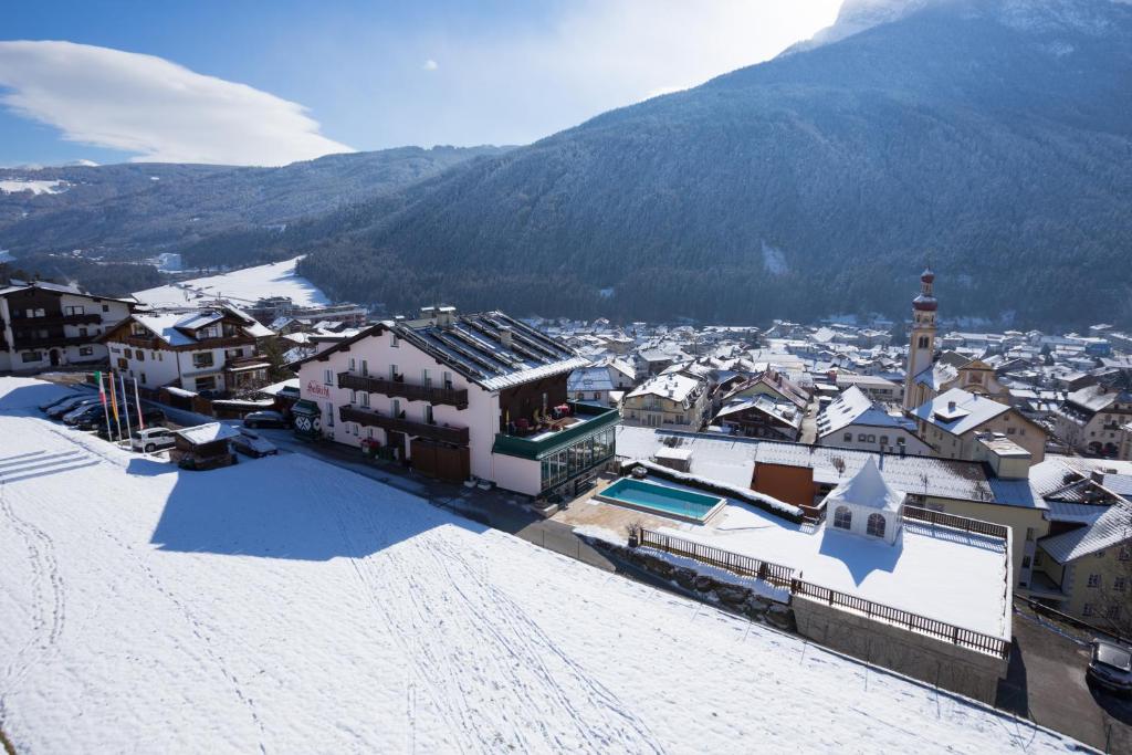 a town with snow covered buildings and a mountain at Hotel Habicht in Fulpmes