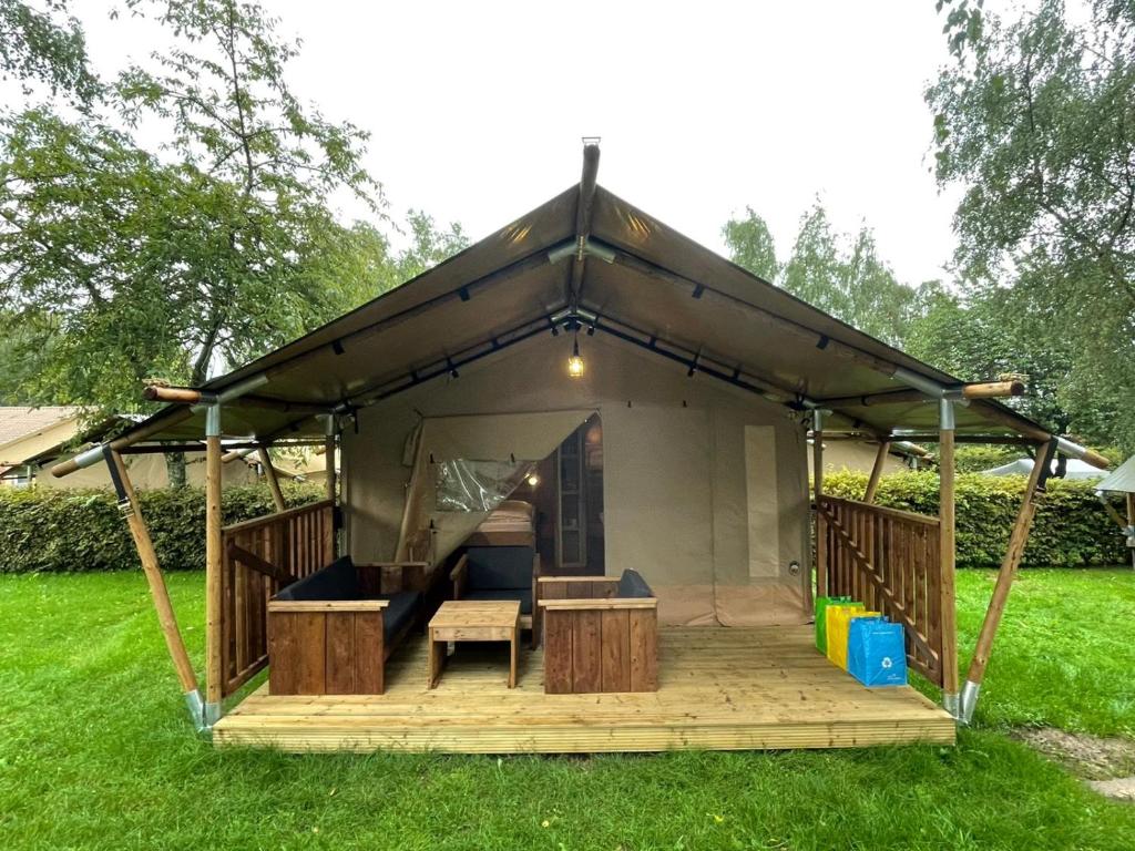 a tent with a wooden deck in a yard at Safari Tent M in Berdorf