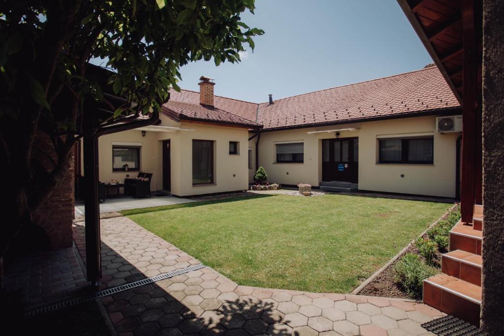 einen Hinterhof eines Hauses mit Rasen in der Unterkunft Apartments Peric Županja in Županja