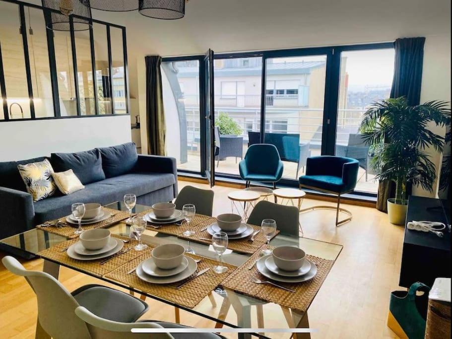 ein Wohnzimmer mit einem Sofa, einem Tisch und Stühlen in der Unterkunft Penthouse 2 bedrooms in Center with Parking - 51 in Luxemburg (Stadt)