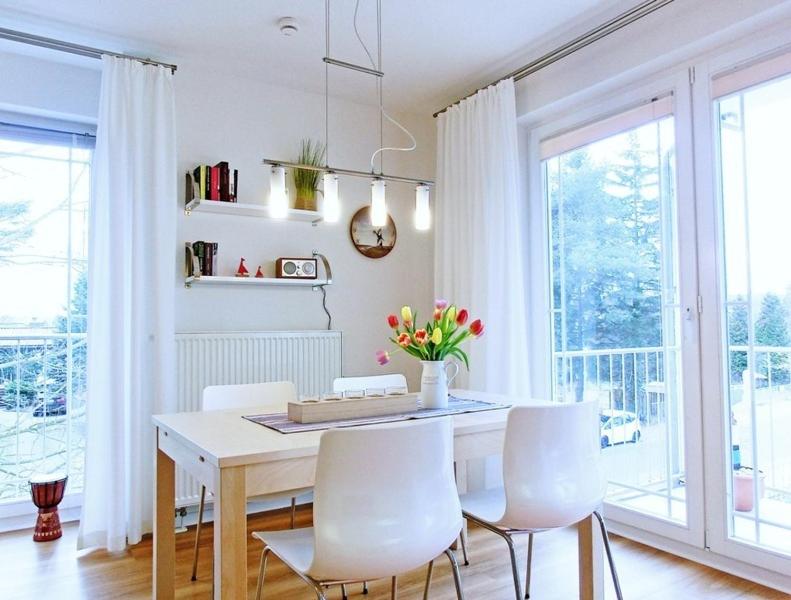 Strandoase - FeWo 21 في بانسين: غرفة طعام مع طاولة وكراسي بيضاء