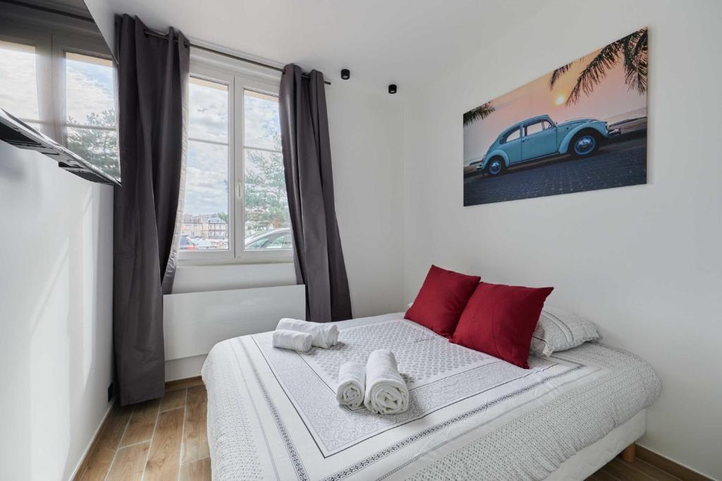 1 dormitorio con 1 cama con toallas en Amazing place with patio, en Deauville
