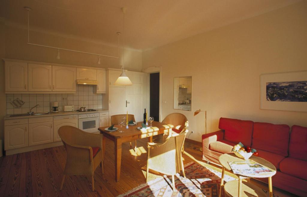 ein Wohnzimmer mit einem roten Sofa und einem Tisch in der Unterkunft Villa Daheim - FeWo 01 in Ostseebad Kölpinsee