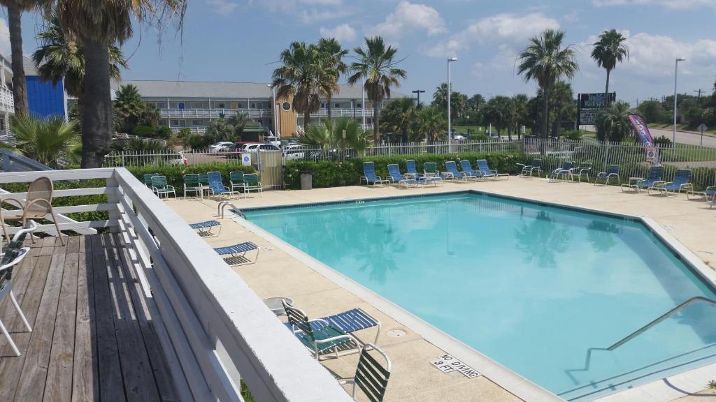 una piscina en un complejo con sillas y un tobogán en Inn at the Waterpark, en Galveston