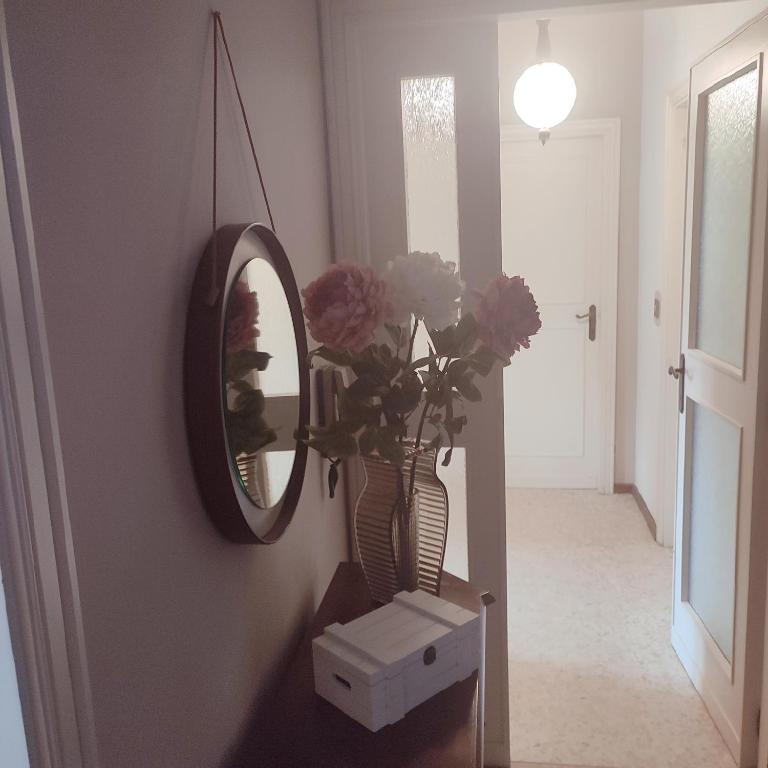 a hallway with a mirror and a vase with flowers at Casa Tanja in Pescara