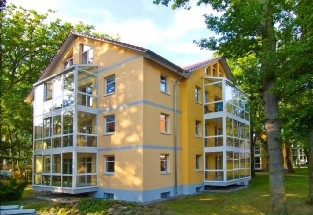 バンシンにあるOstseepark Waterfront Karavelle Wohnung 3.5の木立の大きな黄白の建物
