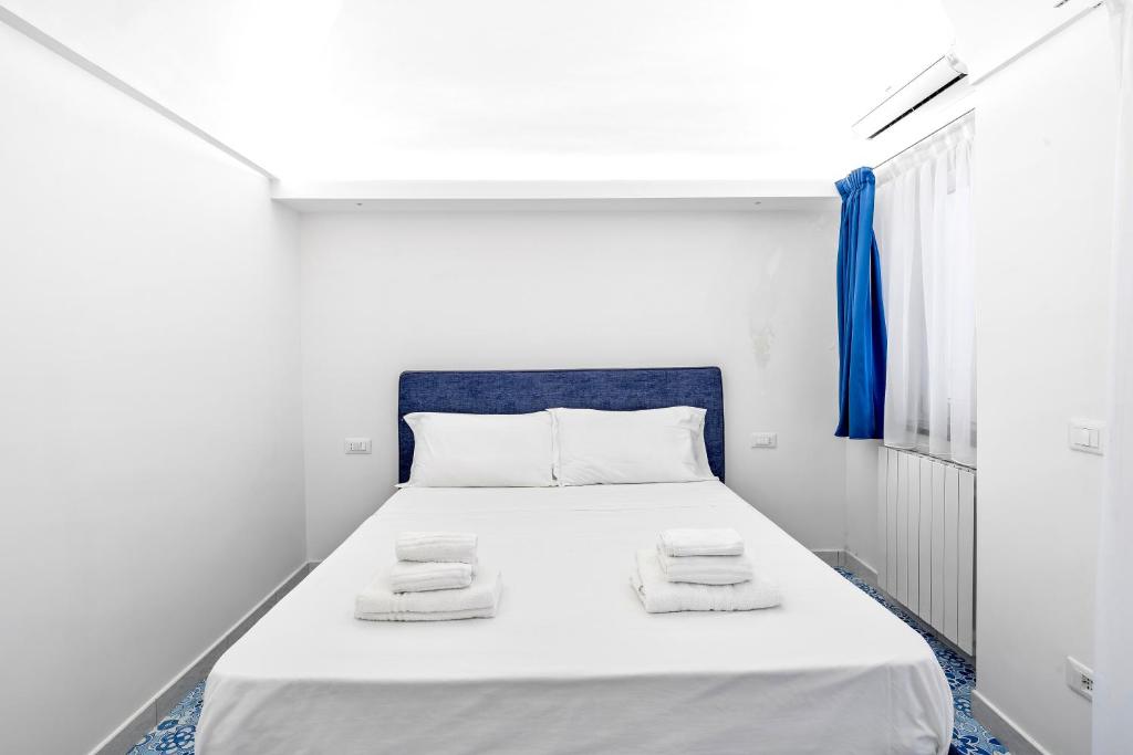 ein weißes Schlafzimmer mit einem Bett mit Handtüchern darauf in der Unterkunft LUXE Minimal Retreat, Amalfi Coast - AirHome in Vico Equense